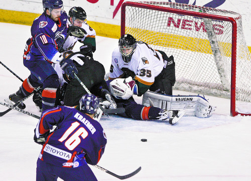 Utah Grizzlies goalie Shane Owen (35) keeps his eye on the puck as Ontario Reign's Kyle Kraemer (16) looks to rush in on the rebound during first period play in Game 3 of the ECHL playoffs at the Maverick Center, Friday, April 5, 2013, in West Valley City, Utah. (AP Photo/The Salt Lake Tribune, Scott Sommerdorf)  DESERET NEWS OUT; LOCAL TV OUT; MAGAZINES OUT