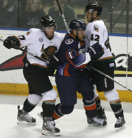 Utha Grizzlies' Jordan Clendenning, left, and Even Stoflet (42) sandwich Ontario Reign's Brady Calla in ECHL hockey playoff game action at the Maverick Center, Saturday, April 6, 2013, in West Valley City, Utah. (AP Photo/The Salt Lake Tribune, Rick Egan)  LOCAL TV OUT; MAGAZINES OUT; DESERET NEWS OUT