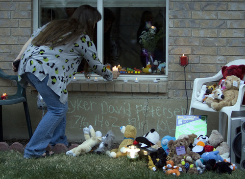 Kim Raff  |  The Salt Lake Tribune
Sherry Hunter places a candle on a memorial for 5-month-old Ryker Petersen during a candlelight vigil for the baby in American Fork on April 7, 2013. Police say Ryker was shot to death on Friday by his father, Joshua Petersen.