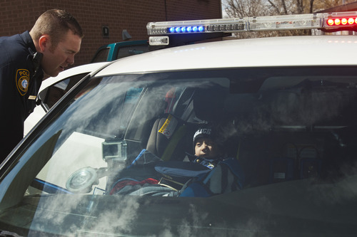 Chris Detrick  |  The Salt Lake Tribune
Granite School District Police Officer Michael Erickson gets Brandon Royo, 9, ready to ride in his police car outside his apartment in West Valley City Tuesday March 26, 2013. Royo, a second grade student at Whittier Elementary, is dying from medulloblastoma, a form of brain cancer.