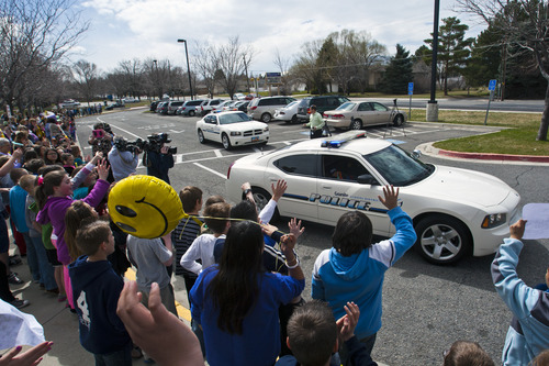 Chris Detrick  |  The Salt Lake Tribune
Fellow students hold signs and cheer for Brandon Royo, 9, as he rides in a police car driven by Granite School District Police Officer Michael Erickson at Whittier Elementary in West Valley City Tuesday March 26, 2013. Royo, a second grade student at Whittier Elementary, is dying from medulloblastoma, a form of brain cancer.