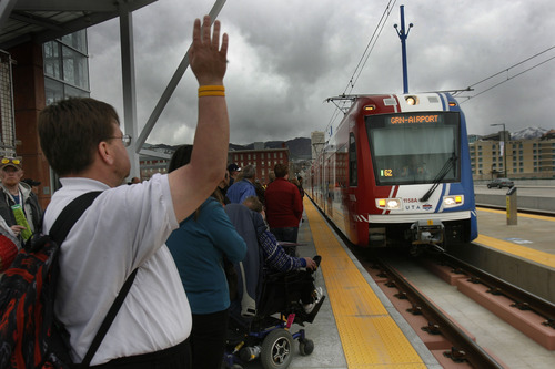 Scott Sommerdorf   |  The Salt Lake Tribune
Riders prepare to board the TRAX train at North Temple Bridge Station as it heads west on North Temple on it's way to the airport. The "Food is Your Fare" event took place from 10 a.m. to 10 p.m. At all stations one can donate a can of food at the bins located near the stations to ride the new Airport Line before it opens,  Saturday, April 13, 2013.