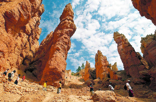 Tribune File Photo
Hikers are dwarfed by the tall red spires as they descend the the Wall Street section on the Navajo Loop Trail, the most popular trail in Bryce National Park. Admisison is free to all national parks on Veterans Day weekend.