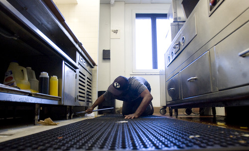 Kim Raff  |  The Salt Lake Tribune
Gilbert Williams, an Army veteran, crawls on greasy floor mats to sweep under the serving area of the canteen in the George E. Wahlen Department of Veterans Affairs Medical Center in Salt Lake City on April 12, 2013. "I take a lot of pride in my work," says Williams. Williams lost his job of 14 years when Hostess closed last fall, but didn't want to coast on unemployment. By January, he had three job offers and took a housekeeping aide job at the medical center.