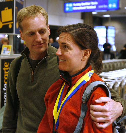 Rick Egan  | The Salt Lake Tribune 

Mike Davey hugs his wife Kellie Davey at the Salt Lake International Airport, after they returned from Boston Monday evening, April 15, 2013.  Kellie had just finished the Boston Marathon, when the explosions went off.