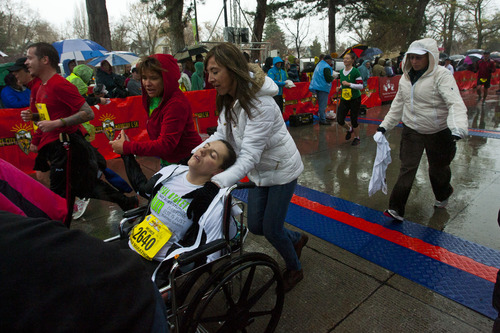 Chris Detrick  |  The Salt Lake Tribune
Amy Hatch, 21, of Salt Lake City, is helped across the finish line after collapsing during the last 20 yards of the Salt Lake City marathon at Liberty Park Saturday April 20, 2013.