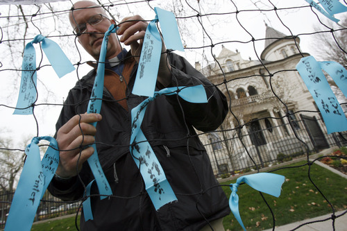 Francisco Kjolseth  |  The Salt Lake Tribune
Rev. David Nichols of Mount Tabor Lutheran Church attaches a blue ribbon with a personal note about the environment as Utah citizens gather to push for clean air, clean energy and a clean future in front of the governor's mansion in Salt Lake City on Earth Day, Monday April 22, 2013. The group was asking the governor to be more responsive in addressing air pollution concerns and embracing clean energy.