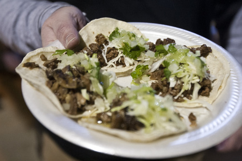 Chris Detrick  |  The Salt Lake Tribune
Rob Perkins, sous chef at Franck's Restaurant, eats carnitas and lengua tacos at Tacos "Don Rafa" cart near 750 S. State St. in Salt Lake City on Thursday April 11, 2013.