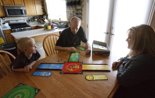 Leah Hogsten  |  The Salt Lake Tribune
Jeremy York plays a board game at home with his wife Holly and son Keagan, 5, Wednesday, April 24, 2013. York was scheduled to go to work as a haul truck driver at Kennecott Copper Mine but had his job offer rescinded after the landslide covered half of the pit.