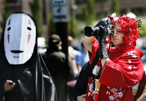 Scott Sommerdorf  |  The Salt Lake Tribune             
The Nihom Matsuri Japan Festival is Saturday, April 27, 2013, in Salt Lake City. In this photo from the 2012 festival, Li Vincent makes photos of the Kimono contest while "NoFace" a character from the Hayao Miyazaki animated Japanese movie "Spirited Away" watches at left.