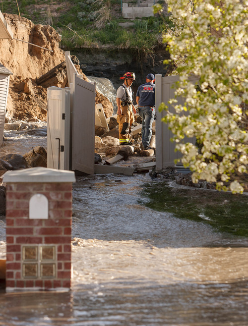 Trent Nelson  |  The Salt Lake Tribune
Firefighters examine a canal breach that sent water flooding into a Murray neighborhood Saturday, April 27, 2013.