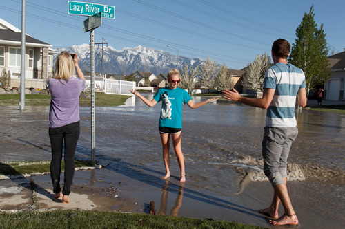 Trent Nelson  |  The Salt Lake Tribune
Shandi Schoeneman, center, poses for a photo on Lazy River Drive after a canal breach sent water flooding into a Murray neighborhood Saturday, April 27, 2013.