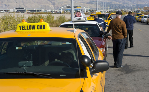 Al Hartmann  |  Tribune file photo
Taxi drivers queue up for fares south of Salt Lake City International Airport. Two local cab companies that were passed over for contracting for on-demand services to two out-of-state firms are challernging the decision.