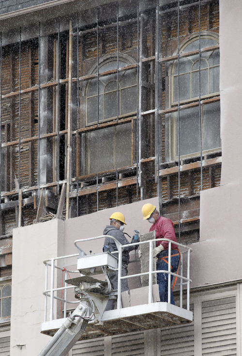 Al Hartmann  |  The Salt Lake Tribune
Workers on a lift remove the facade from a building at 150 South State St. to reveal the historic front underneath.
