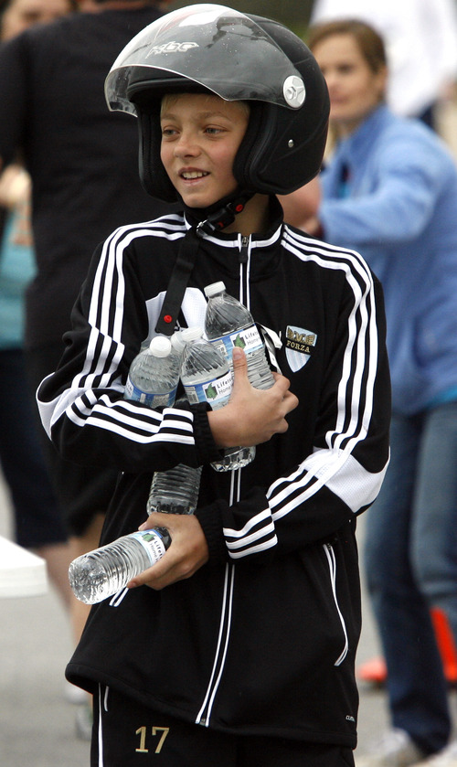 Rick Egan  | The Salt Lake Tribune 

Twelve-year-old Kol Vanderlinden, hands out water bottles to runners at the finish line of the 5K race, at the Tulip Trot fundraiser for Muir Elementary. Saturday, April 13, 2013.