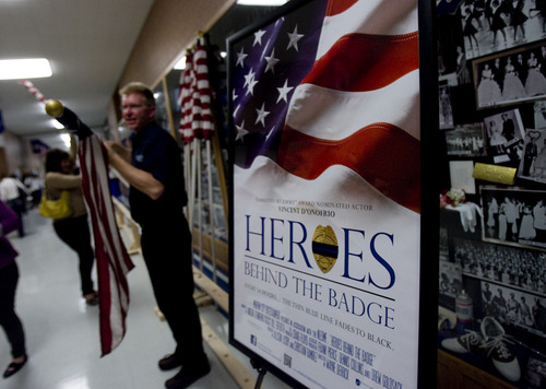 Kim Raff  |  The Salt Lake Tribune
Steve Allred puts away flags after a screening of "Heroes Behind the Badge" at Pleasant Grove High School in Pleasant Grove on April 19, 2013.  The documentary follows the stories of police officers who have been injured or killed in the line of duty.