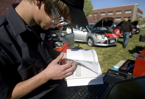 Kim Raff  |  The Salt Lake Tribune
College of Eastern Utah Carbon High School student Phillip Raich looks in a vehicle manual while trying to debug a car during the Ford/AAA Student Auto Skills competition on the Miller Campus of Salt Lake Community College in Sandy on May 2, 2013.  Automotive technology students from twenty of Utah's high schools compete with each other in debugging cars in a timed competition.  The winner will travel to Ford's Headquarters in Dearborn, MI for the national finals.