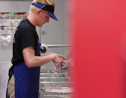 Trent Nelson  |  The Salt Lake Tribune
Marc Aust works on pizzas under the eye of a camera at a Dominos Pizza location in Lehi Thursday, May 2, 2013. Dominos is streaming live video of the pizza-making process in the Lehi store.