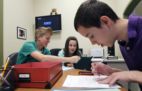 Al Hartmann  |  The Salt Lake Tribune
North Star Academy eighth-graders Dalton McClees, Amelia Dieterich and Jackson Abel use pencils, paper and calculators to put together a family budget in a hands-on lesson in personal finance at Junior Achievement City on Monday, April 29.