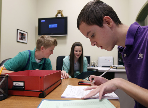 Al Hartmann  |  The Salt Lake Tribune
North Star Academy eighth-graders Dalton McClees, Amelia Dieterich and Jackson Abel use pencils, paper and calculators to put together a family budget in a hands-on lesson in personal finance at Junior Achievement City on Monday, April 29.