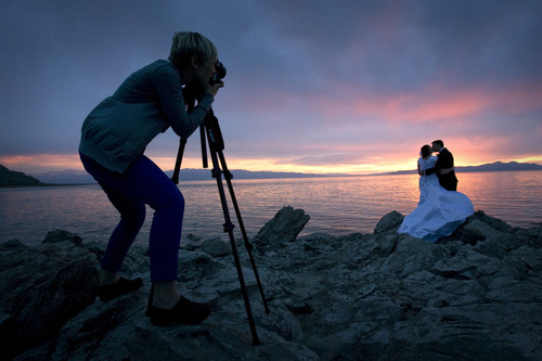 Rick Egan  | The Salt Lake Tribune 

Susan Adams takes advantage of the sunset, as she shoots wedding photos of Emily Mecham, Brian Shaw, Provo, at the Great Salt Lake, Monday, May 6, 2013.
