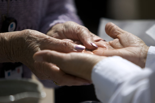 Kim Raff  |  The Salt Lake Tribune
(left) Myrna Hirst blesses the hands of Gabriela Cetrola, a social work at the hospital, during the "Blessing of the Hands" on the outdoor patio of the Huntsman Cancer Institute in Salt Lake City on May 6, 2013. The event gathered a diverse group of spiritual care providers to bless hospital caregivers, employees  and patrons.