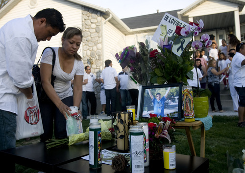 Alex Flores, left, and Silvia Castro place candles at a vigil for Ricardo Portillo, who passed away after injuries he sustained after an assault by a soccer player at a soccer game he was refereeing on April 27, in Salt Lake City on Sunday, May 5, 2013. (AP Photo/The Salt Lake Tribune, Kim Raff)