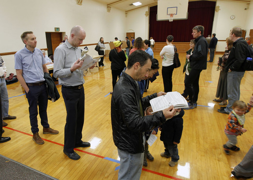 Al Hartmann  |  Tribune file photo
People look over voting guides Tuesday morning, Nov. 6 as they wait to vote at the Salt Lake Ensign LDS Church at 109 G St. in Salt Lake City, which houses precincts SLC033 and SLC039.