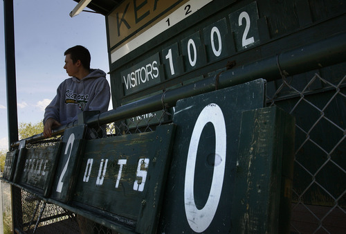 Scott Sommerdorf   |  The Salt Lake Tribune
Scoreboard operator Nate Seltsam watches the action as he keeps score on the analog scoreboard at Gates Field at Kearns High. Emery defeated Millard 4-3 in it's 2A baseball playoff game played at Kearns High, Thursday, May 9, 2013. They advance to tomorrow's 2A semi-final.