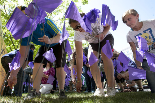 Steve Griffin  |  The Salt Lake Tribune
Foster care families push purple flags into the ground at the City and County Building during the Utah Foster Care's March for Kids down State Street in Salt Lake City Friday May 10, 2013. Foster families were joined by police officers and firefighters as they celebrate National Foster Care Month.