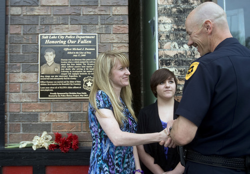 Kim Raff  |  The Salt Lake Tribune
Sandi Bromley shakes hands with Salt Lake City Police Chief Chris Burbank during Salt Lake Police Department dedication of a plaque in memory of her husband, Officer Michael Dunman, who was killed while on duty 13 years ago, outside Piper Down Pub in Salt Lake City on May 17, 2013.