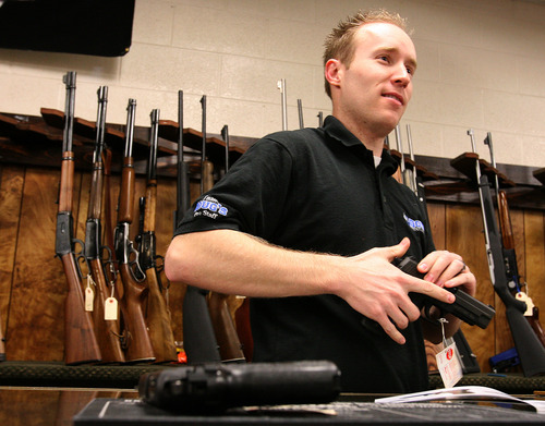 Leah Hogsten  |  Tribune file photo
The sales manager of Doug's Shoot 'N Sports sells a handgun in the Taylorsville store. Utahns set a record in December, purchasing some 23,000 guns. That was triple the average monthly sales for the year -- which by itself set an all-time record for gun purchases.