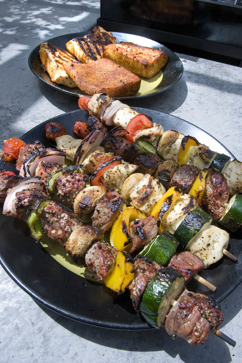 Paul Fraughton  |  The Salt Lake Tribune
Beef kabobs and grilled and cedar plank salmon are ready to be served.