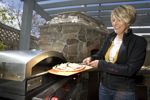 Paul Fraughton  |  The Salt Lake Tribune
Sue Measom slides a pizza into the new Camp Chef pizza oven.