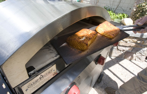 Paul Fraughton  |  The Salt Lake Tribune
Cedar plank salmon comes out of the pizza oven.