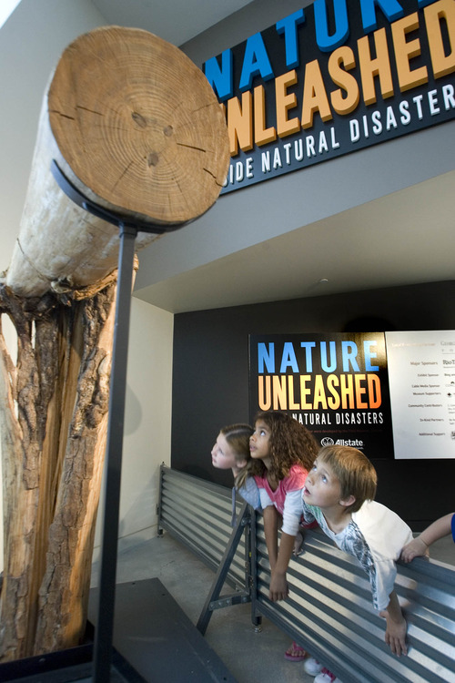 Paul Fraughton  |  The Salt Lake Tribune
Second-graders from Grant Elementary School in Murray, Alexus Little, Jada Jaramillo and Camron Pennington, lean in to look at a tree trunk that was broken in two by the force of winds from Hurricane Hugo. The youngsters got a preview look at the exhibit "Nature Unleashed" opening at The Natural History Museum on Saturday.