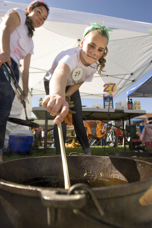 Paul Fraughton  |  The Salt Lake Tribune
Lesley Olson tends one of her Dutch ovens as her cooking partner Sena Smith looks on. The pair were one of the 54 teams participating in  Riverview Jr. High School's ninth-grade Dutch oven cook-off.                         
 Friday, May 10, 2013