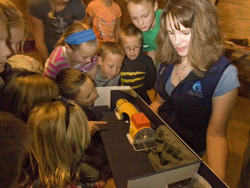 Paul Fraughton  |  The Salt Lake Tribune
Fourth-graders from Castle Dale Elementary gather around Ashley Kerbs of The Living Planet Aquarium in Sandy who is holding a model of the exhibit  on undersea water pressure that is planned for the aquarium's new location.                     
 Tuesday, May 7, 2013