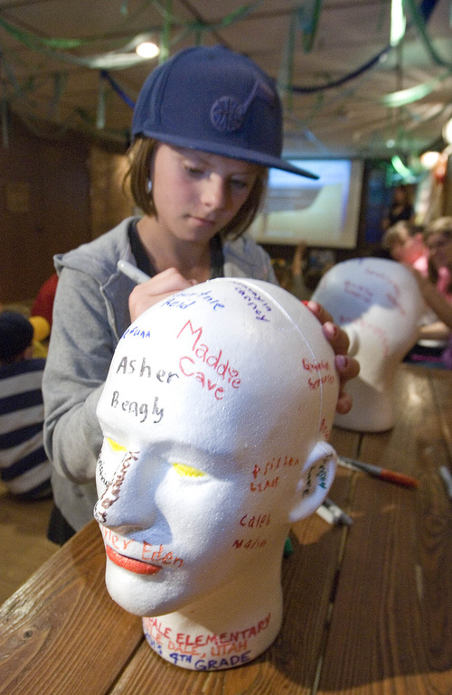 Paul Fraughton  |  The Salt Lake Tribune
Sarahlynn Peterson signs her name on a styrofoam head that will be compressed by water pressure when it is sent into the deep sea. The children from Castle Dale  Elementary participated in the activity at The Living Planet Aquarium in Sandy. The heads will become part of a new exhibit planed for the new aquarium showing the effects of pressures under the sea.                  
 Tuesday, May 7, 2013