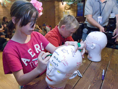 Paul Fraughton  |  The Salt Lake Tribune
Lindsay Peterson and Tyler Eden joined their fourth-grade class from Castle Dale Elementary School at The Living Planet Aquarium to take part in the creation of an exhibit showing the effects of water pressure under the sea. She, along with her classmates, signed their names on a styrofoam head that will go under the sea and be compressed by the pressures there.