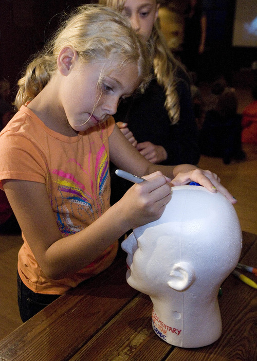 Paul Fraughton  |  The Salt Lake Tribune
Courtnie Reid joined her fourth-grade class from Castle Dale Elementary School at The Living Planet Aquarium to take part in the creation of an exhibit showing the effects of water pressure under the sea. She, along with her classmates, signed their names  on a styrofoam head that will go under the sea and be compressed by the pressures there.              
 Tuesday, May 7, 2013