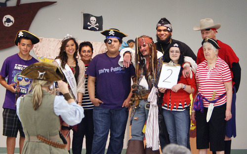 Steve Griffin  |  The Salt Lake Tribune
Kearns High School students and senior citizens pause for photos during a pirate themed "Senior Prom." Students who have volunteered at the Kearns Senior Center held the prom with the seniors that included a scavenger hunt, talent show and the crowning of the king and queen of the prom. The prom was held at the Kearns Senior Center in Kearns.