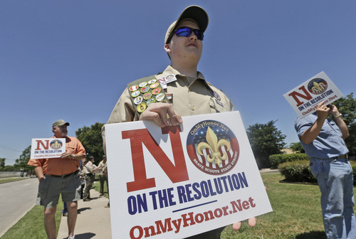 Matthew Ray, 15, of North Richland Hills, Texas, holds signs near where the Boy Scouts of America are holding their annual meeting Wednesday, May 22, 2013, in Grapevine, Texas. Delegates to the meeting are expected to address a proposal to allow gay scouts into the organization. (AP Photo/LM Otero)