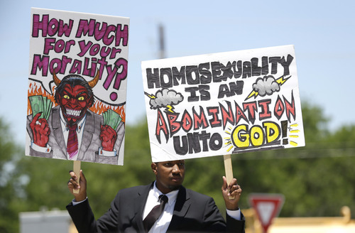 An unidentified protestor holds a sign near where the Boy Scouts of America is holding their annual meeting Wednesday, May 22, 2013, in Grapevine, Texas. Delegates to the meeting are expected to address a proposal to allow gay scouts into the organization. (AP Photo/LM Otero)