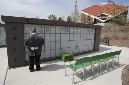 Steve Griffin  |  The Salt Lake Tribune
An outdoor Columbarium is part of the Utah Veterans Cemetery and Memorial Park's $5 million worth of improvements. Cremated ashes of veterans and their spouses are placed in the niches (recessed compartments) behind each name plate. Here Terry Schow, executive director of the Utah Department of Veterans Affairs, reads the names of veterans, whose ashes are in the Columbarium. Schow championed the project and is retiring at the end of June. The cemetery, located in Bluffdale, Utah was photographed Monday May 6, 2013.