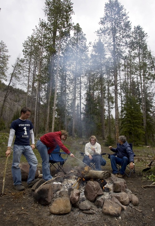 Camping friends, from left, Nate Falslev of American Fork, Laura Given of West Valley City, Stefanie Lamb of Magna and Mike Bayfield of Granger cook food on a mild Sunday afternoon in the Wasatch National Forest in the Uinta mountains Sunday, May 25, 2008 near the entrance of the Soapstone campground on the Mirror Lake Byway. Cooler than usual temperatures were present for the Memorial Day weekend and the snow persisted in the higher elevations closing roads and campgrounds. 05/25/2008 Jim Urquhart/The Salt Lake Tribune