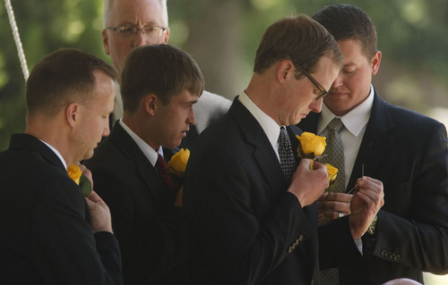 Leah Hogsten  |  The Salt Lake Tribune
Monson family members remove their boutonnieres to place on the casket of  Frances J. Monson, wife of LDS Church President Thomas S. Monson, who was laid to rest in the Salt Lake City Cemetery, Thursday, May 23, 2013. Frances Monson died Friday at age 85 after having been hospitalized for several weeks. The Utah-based Church of Jesus Christ of Latter-day Saints said she died of causes incident to age.