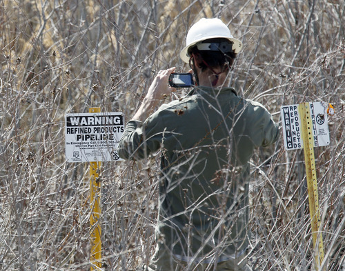 Al Hartmann  |  The Salt Lake Tribune
A man photographs a pipeline sign near a petroleum spill in a wetland area between Willard Bay North Marina and I-15 Tuesday March 19. The leak was detected Monday. Authorities said the leak was contained in retaining ponds and none went into Willard Bay.