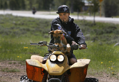 Scott Sommerdorf   |  The Salt Lake Tribune
Taylor Lee starts up his ATV with his dog "Jerzy" on board near his family's camp near State Route 150. The Mirror Lake Highway is now open just in time for the Memorial Day weekend, Sunday, May 26, 2013.