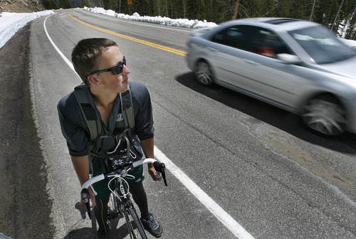 Scott Sommerdorf   |  The Salt Lake Tribune
A car passes UVU student Landon Bartlett along the Mirror Lake Highway on Sunday.